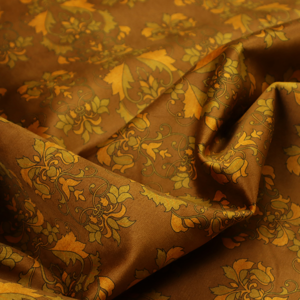 An ornate, vintage-style damask fabric featuring repeating, intricate botanical motifs in rich shades of burnt orange, gold, and deep brown with a subtly aged, textured appearance.