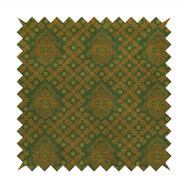A repeating, decorative fabric pattern featuring ornate, gold-toned paisley motifs centred on a deep forest green background. The design is structured around a subtle lattice of small, delicate floral sprigs, creating a traditional, block-printed aesthetic with a slightly weathered, vintage texture.