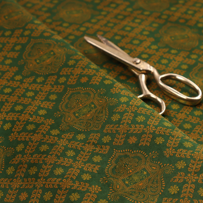 A repeating, decorative fabric pattern featuring ornate, gold-toned paisley motifs centred on a deep forest green background. The design is structured around a subtle lattice of small, delicate floral sprigs, creating a traditional, block-printed aesthetic with a slightly weathered, vintage texture.