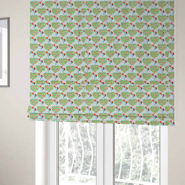 The fabric used to create these Roman blinds is a repeating pattern on a light blue-grey background. The pattern consists of rows of heart shapes made of green vines and small pink and red flowers. Each heart is topped with a red flower on a thin blue stem and flanked by another red flower on its own blue stem. These floral elements repeat across the entire fabric.
