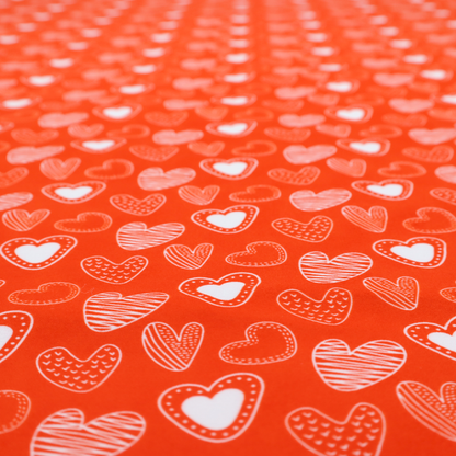 This vibrant red fabric features a playful, repeating pattern of white heart illustrations. The hearts are hand-drawn in several distinct styles, including solid outlines with dotted borders, sketched diagonal stripes, and intricate stippled patterns. These varied heart motifs are scattered across the bright background at different angles, creating a lively and energetic design.