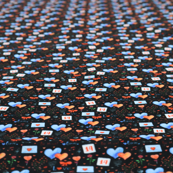 This black fabric features a dense, romantic Valentine’s Day theme with a repeating pattern of watercolour-style motifs. The design includes blue and red hearts, small sealed envelopes, red bows, and calendar pages marked with the number "14". 