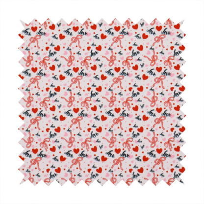 This light pink fabric features a dense, repeating Valentine’s Day pattern with a vintage, romantic aesthetic. The design is composed of small red hearts and larger pink hearts, interspersed with delicate red ribbon bows and the word "love" written in a dark, flowing cursive script. Tiny red dots are scattered throughout the background, creating a textured, confetti-like effect across the entire print.