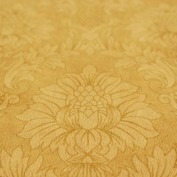 Luxurious tonal gold damask fabric featuring a repeating symmetrical floral medallion pattern in shimmering amber and matte ochre tones.
