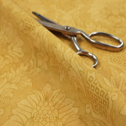 Luxurious tonal gold damask fabric featuring a repeating symmetrical floral medallion pattern in shimmering amber and matte ochre tones.