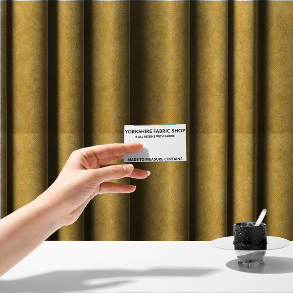 The fabric used to create these made-to-measure curtains is a luxurious tonal gold damask fabric featuring a repeating symmetrical floral medallion pattern in shimmering amber and matte ochre tones.