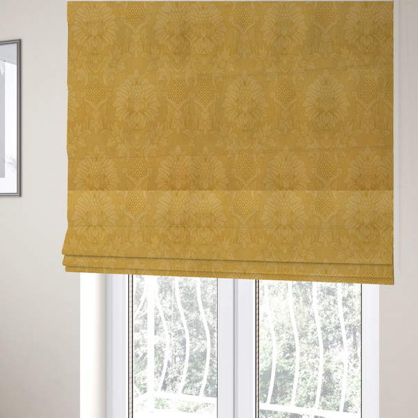 The fabric used to create these Roman blinds is a luxurious tonal gold damask fabric featuring a repeating symmetrical floral medallion pattern in shimmering amber and matte ochre tones.