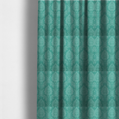 The fabric used to create these made-to-measure curtains is a vibrant teal damask fabric featuring a large-scale, repeating floral and acanthus leaf pattern in a tonal, monochromatic seafoam green colourway.