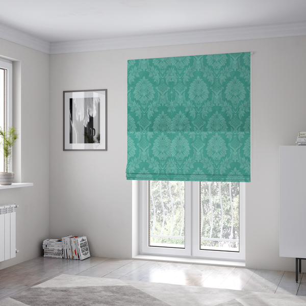 The fabric used to create these Roman blinds is a vibrant teal damask fabric featuring a large-scale, repeating floral and acanthus leaf pattern in a tonal, monochromatic seafoam green colourway.