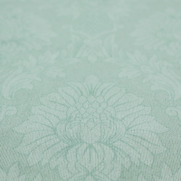 Pale ice blue damask fabric with a subtle, low-contrast floral medallion pattern in light pastel tones.