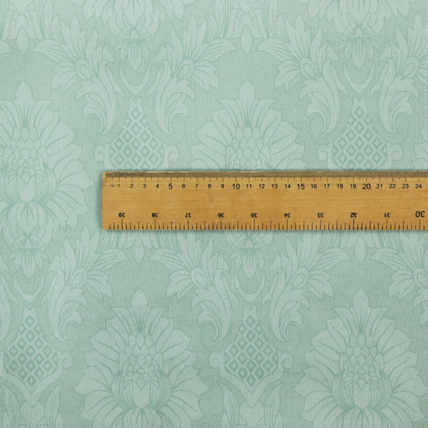 Pale ice blue damask fabric with a subtle, low-contrast floral medallion pattern in light pastel tones.
