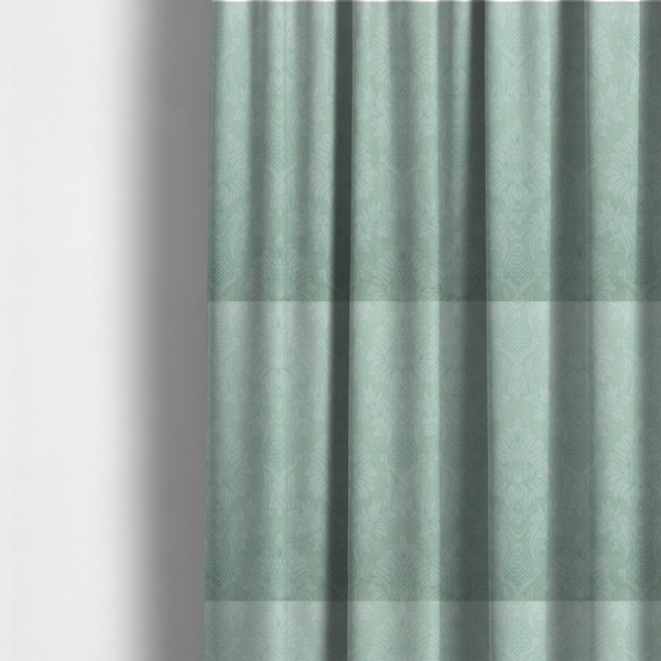 The fabric used to create these made-to-measure curtains is a pale ice blue damask fabric with a subtle, low-contrast floral medallion pattern in light pastel tones.