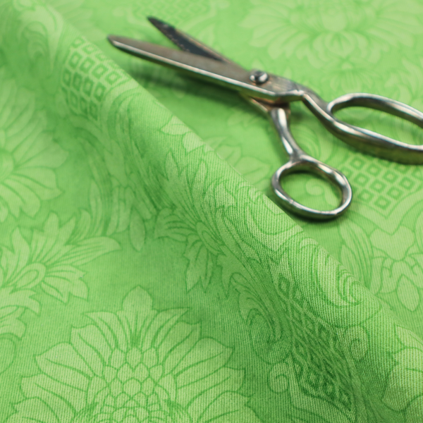 Vibrant apple green damask fabric featuring a repeating, large-scale floral medallion and acanthus leaf pattern in a tonal monochromatic colourway.