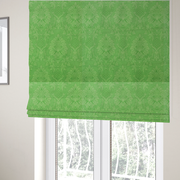 The fabric used to create these Roman blinds is a vibrant apple green damask fabric featuring a repeating, large-scale floral medallion and acanthus leaf pattern in a tonal monochromatic colourway