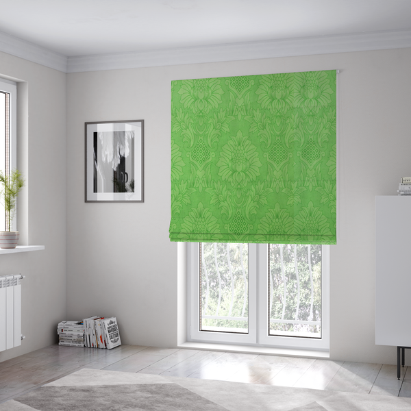 The fabric used to create these Roman blinds is a vibrant apple green damask fabric featuring a repeating, large-scale floral medallion and acanthus leaf pattern in a tonal monochromatic colourway