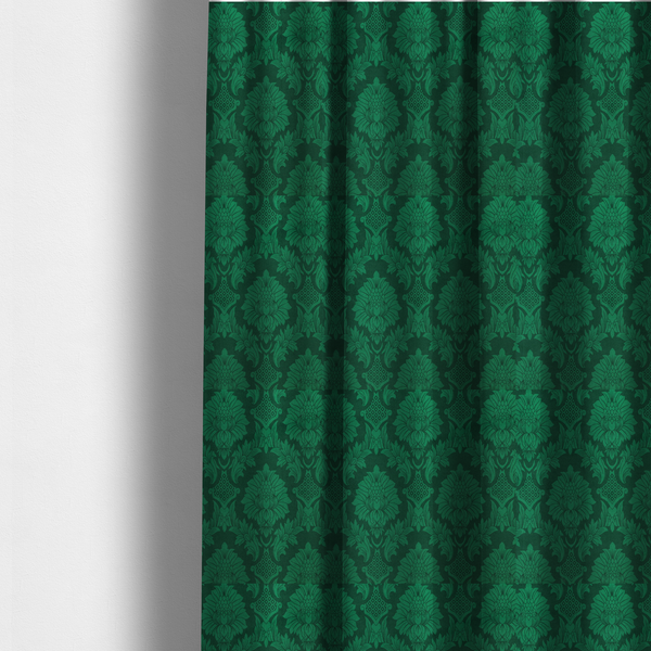 The fabric used to create these made-to-measure curtains is a deep emerald green damask fabric featuring a large-scale, repeating floral and acanthus leaf pattern in a rich tonal colourway.