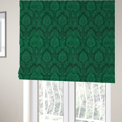The fabric used to create these Roman blinds is a deep emerald green damask fabric featuring a large-scale, repeating floral and acanthus leaf pattern in a rich tonal colourway.
