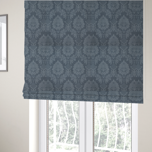 The fabric used to create these Roman blinds is a sophisticated slate blue damask fabric featuring a large-scale, repeating floral and acanthus leaf pattern in a tonal, steel grey colourway.