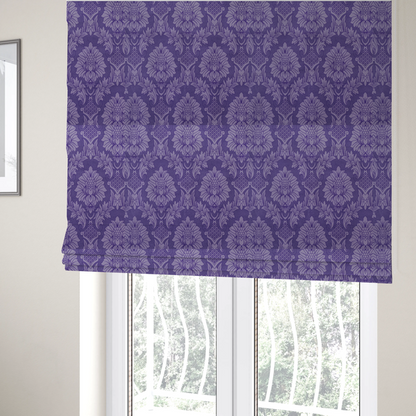 The fabric used to create these Roman blinds is a regal royal purple damask fabric featuring a large-scale, repeating floral and acanthus leaf pattern in a shimmering tonal violet colourway.