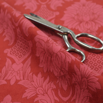 Rich crimson red damask fabric featuring a large-scale, repeating floral and acanthus leaf pattern in a shimmering tonal colourway.