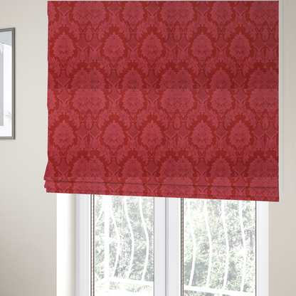 The fabric used to create these Roman blinds is a rich crimson red damask fabric featuring a large-scale, repeating floral and acanthus leaf pattern in a shimmering tonal colourway.