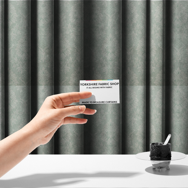 The fabric used to create these made-to-measure curtains is a elegant pale grey damask fabric featuring a large-scale, repeating floral medallion pattern in shimmering silvery-white tones.