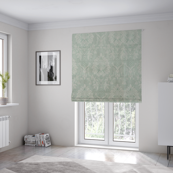 The fabric used to create these Roman blinds is a elegant pale grey damask fabric featuring a large-scale, repeating floral medallion pattern in shimmering silvery-white tones.