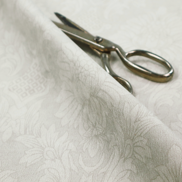 Off-white and silver-grey damask fabric with a large-scale, repeating floral medallion pattern in a subtle, shimmering tonal colourway.