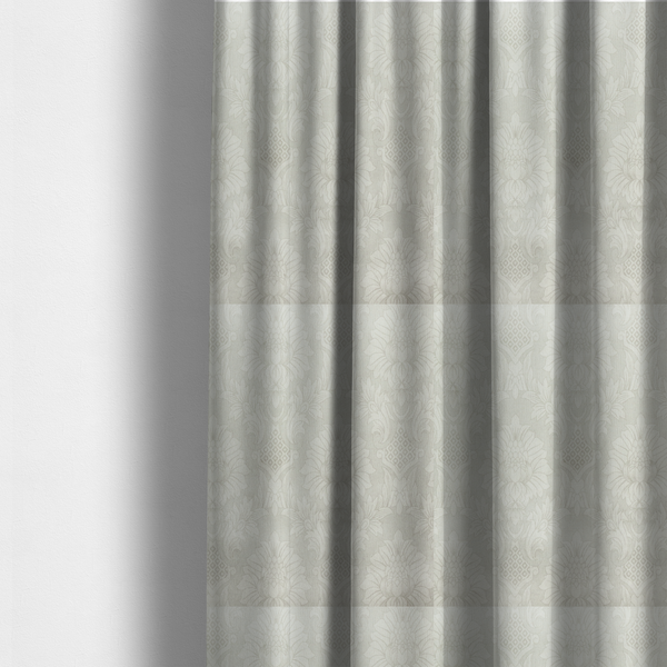 The fabric used to create these made-to-measure curtains is a off-white and silver-grey damask fabric with a large-scale, repeating floral medallion pattern in a subtle, shimmering tonal colourway.