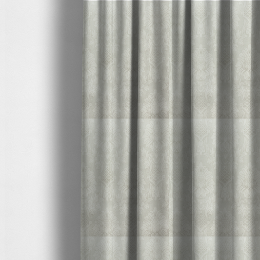 The fabric used to create these made-to-measure curtains is a off-white and silver-grey damask fabric with a large-scale, repeating floral medallion pattern in a subtle, shimmering tonal colourway.