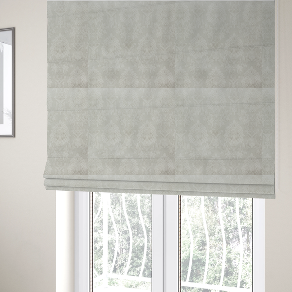 The fabric used to create these Roman blinds is a off-white and silver-grey damask fabric with a large-scale, repeating floral medallion pattern in a subtle, shimmering tonal colourway.