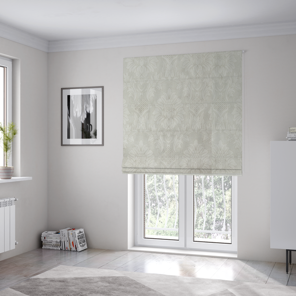 The fabric used to create these Roman blinds is a off-white and silver-grey damask fabric with a large-scale, repeating floral medallion pattern in a subtle, shimmering tonal colourway.