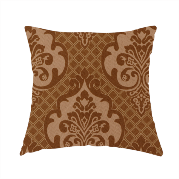 The fabric used to create this handmade cushion is a repeating damask pattern in warm shades of copper, cocoa, and tan. Large, ornate floral medallions featuring stylized acanthus leaves and small blossoms are arranged in an alternating grid.