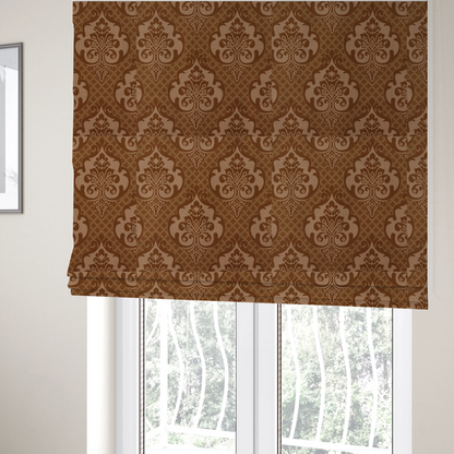 The fabric used to create these Roman blinds is a repeating damask pattern in warm shades of copper, cocoa, and tan. Large, ornate floral medallions featuring stylized acanthus leaves and small blossoms are arranged in an alternating grid.