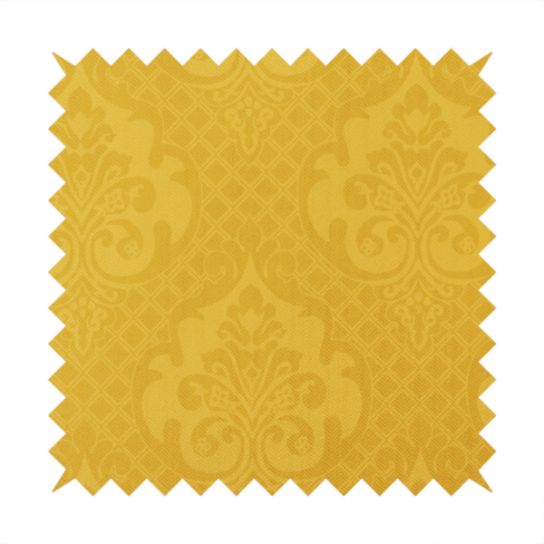 A vibrant yellow damask fabric featuring a tonal, monochrome design. Ornate, stylized floral medallions and acanthus leaves are woven in a slightly lighter shade of yellow, creating a subtle shimmer. The pattern is set against a background of a fine diagonal lattice grid, with a visible woven texture throughout the material.