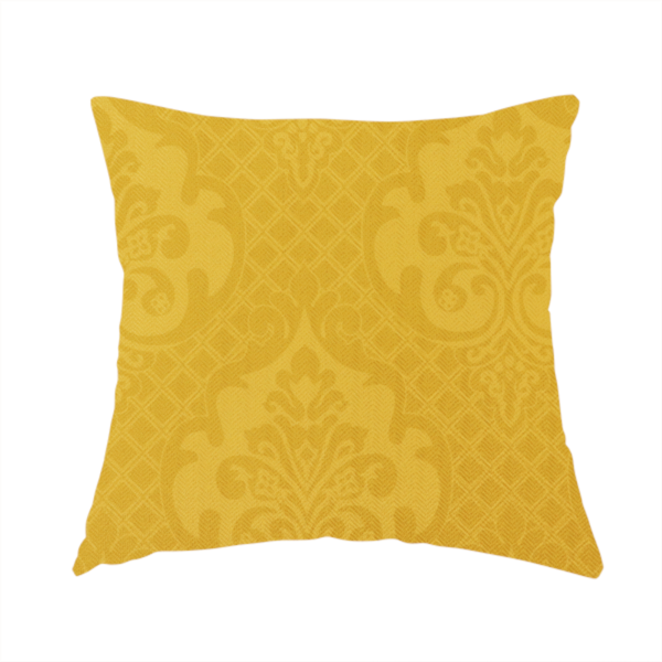 The fabric used to create this handmade cushion is a vibrant yellow damask fabric featuring a tonal, monochrome design. Ornate, stylized floral medallions and acanthus leaves are woven in a slightly lighter shade of yellow, creating a subtle shimmer. The pattern is set against a background of a fine diagonal lattice grid, with a visible woven texture throughout the material.