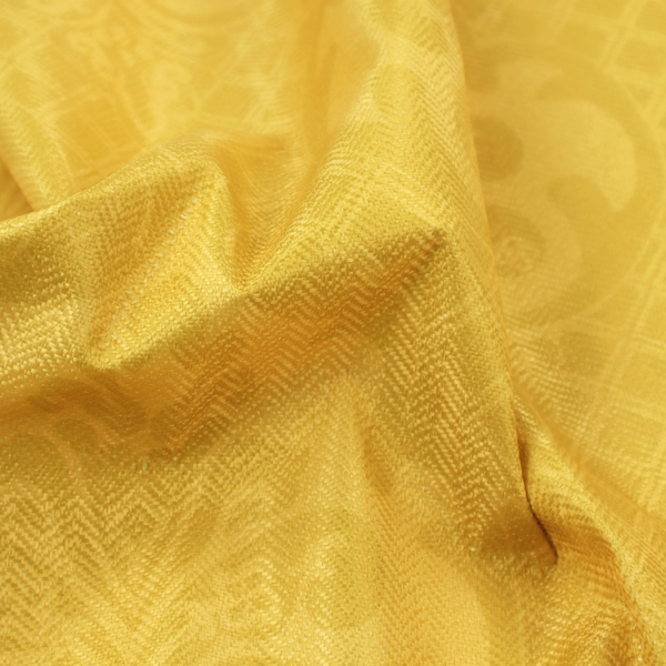 A vibrant yellow damask fabric featuring a tonal, monochrome design. Ornate, stylized floral medallions and acanthus leaves are woven in a slightly lighter shade of yellow, creating a subtle shimmer. The pattern is set against a background of a fine diagonal lattice grid, with a visible woven texture throughout the material.
