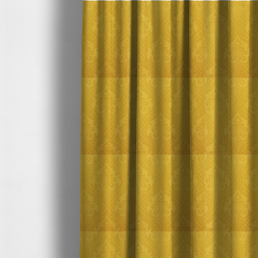 The fabric used to create these made-to-measure curtains is a vibrant yellow damask fabric featuring a tonal, monochrome design. Ornate, stylized floral medallions and acanthus leaves are woven in a slightly lighter shade of yellow, creating a subtle shimmer. The pattern is set against a background of a fine diagonal lattice grid, with a visible woven texture throughout the material.
