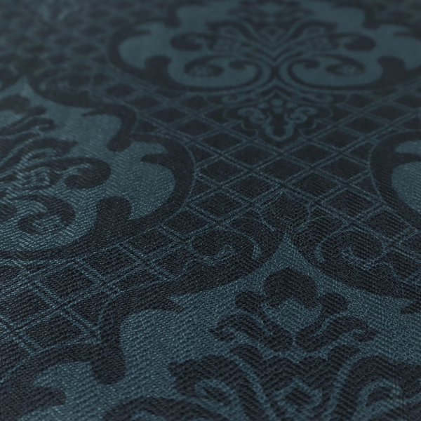 A charcoal damask fabric with a rich, moody aesthetic. The pattern features large, intricate floral medallions and acanthus leaf scrolls in a dark teal hue, set against a slightly darker, nearly black background. A fine diagonal lattice grid fills the spaces between the motifs, and the material displays a clear, woven texture that adds depth to the monochrome design.