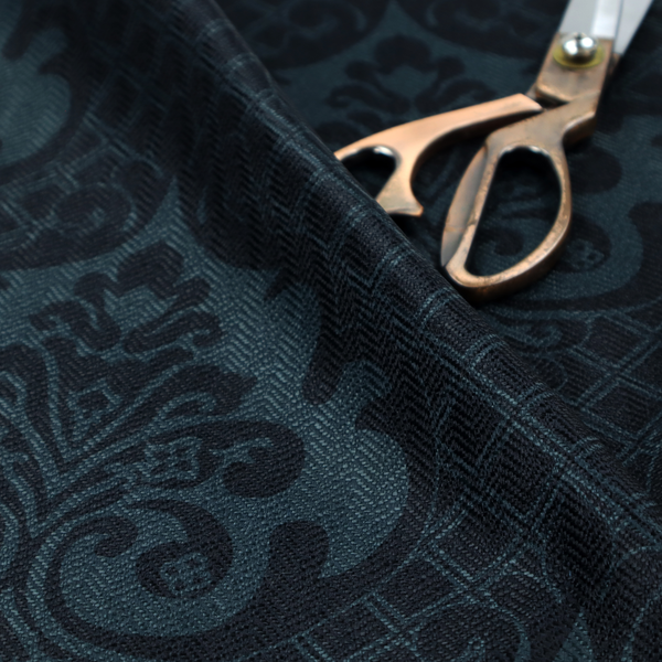 A charcoal damask fabric with a rich, moody aesthetic. The pattern features large, intricate floral medallions and acanthus leaf scrolls in a dark teal hue, set against a slightly darker, nearly black background. A fine diagonal lattice grid fills the spaces between the motifs, and the material displays a clear, woven texture that adds depth to the monochrome design.