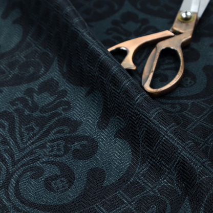 A charcoal damask fabric with a rich, moody aesthetic. The pattern features large, intricate floral medallions and acanthus leaf scrolls in a dark teal hue, set against a slightly darker, nearly black background. A fine diagonal lattice grid fills the spaces between the motifs, and the material displays a clear, woven texture that adds depth to the monochrome design.