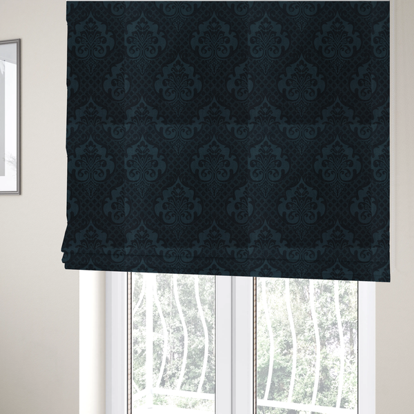 The fabric used to create these Roman blinds is a charcoal damask fabric with a rich, moody aesthetic. The pattern features large, intricate floral medallions and acanthus leaf scrolls in a dark teal hue, set against a slightly darker, nearly black background. A fine diagonal lattice grid fills the spaces between the motifs, and the material displays a clear, woven texture that adds depth to the monochrome design.