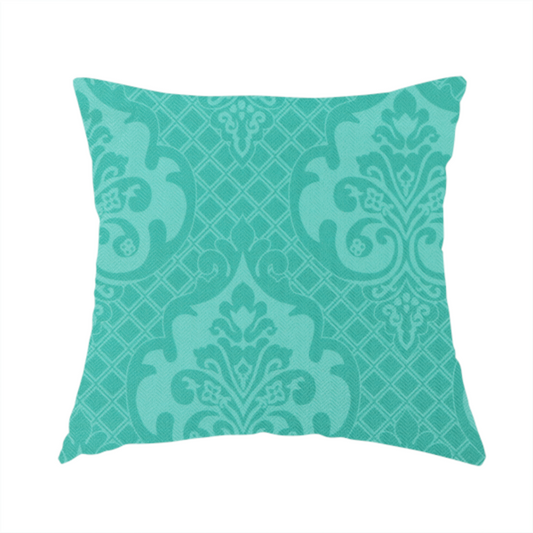 The fabric used to create this handmade cushion has a design that features large, ornate floral medallions and scrolling acanthus leaves in a bright turquoise shade, set against a slightly lighter mint green background. A fine diagonal lattice grid fills the background between the motifs, and the material shows a clear woven texture that provides visual depth to the tonal design.