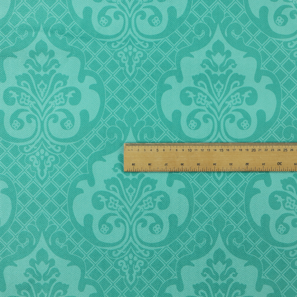 The design features large, ornate floral medallions and scrolling acanthus leaves in a bright turquoise shade, set against a slightly lighter mint green background. A fine diagonal lattice grid fills the background between the motifs, and the material shows a clear woven texture that provides visual depth to the tonal design.
