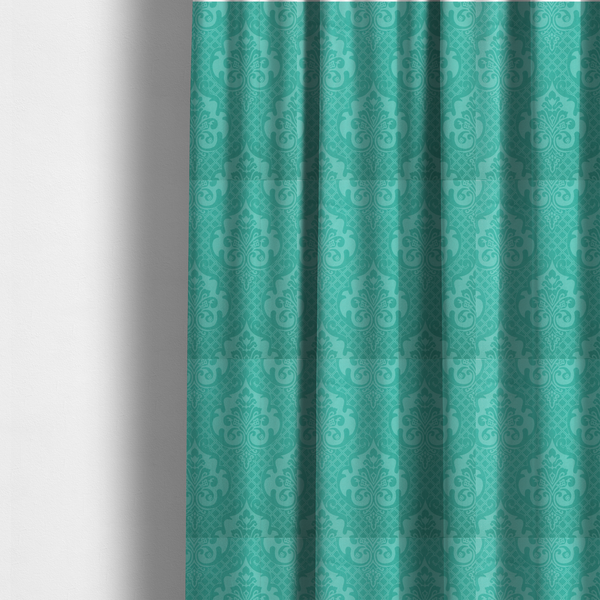 The fabric used to create these made-to-measure curtains has a design that features large, ornate floral medallions and scrolling acanthus leaves in a bright turquoise shade, set against a slightly lighter mint green background. A fine diagonal lattice grid fills the background between the motifs, and the material shows a clear woven texture that provides visual depth to the tonal design.