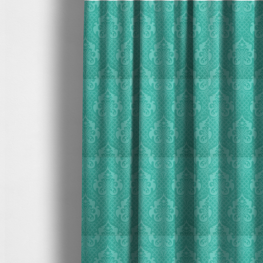 The fabric used to create these made-to-measure curtains has a design that features large, ornate floral medallions and scrolling acanthus leaves in a bright turquoise shade, set against a slightly lighter mint green background. A fine diagonal lattice grid fills the background between the motifs, and the material shows a clear woven texture that provides visual depth to the tonal design.