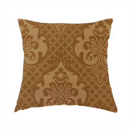 The fabric used to create this handmade cushion has a design that features large, ornate floral medallions and scrolling acanthus leaves in a warm tan shade, set against a rich golden-brown background. A fine diagonal lattice grid creates a diamond pattern in the negative space between the motifs, and the material displays a clear woven texture that adds depth and a subtle sheen to the pattern.