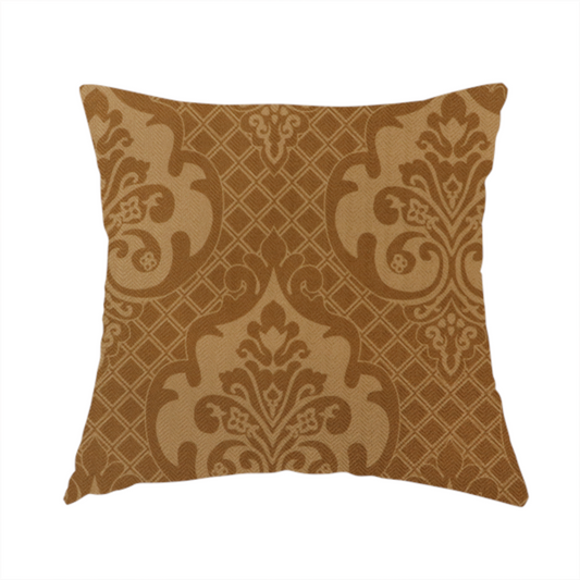 The fabric used to create this handmade cushion has a design that features large, ornate floral medallions and scrolling acanthus leaves in a warm tan shade, set against a rich golden-brown background. A fine diagonal lattice grid creates a diamond pattern in the negative space between the motifs, and the material displays a clear woven texture that adds depth and a subtle sheen to the pattern.