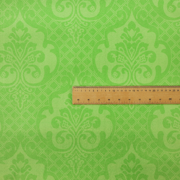 The design features large, ornate floral medallions and scrolling acanthus leaves in a vibrant lime shade, set against a slightly lighter green background. A fine diagonal lattice grid fills the background between the motifs, and the material shows a clear woven texture that provides visual depth to the tonal design.