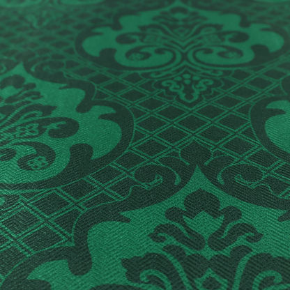 The design showcases large, ornate floral medallions and scrolling acanthus leaves in a vibrant green hue, set against a darker, forest green background. A fine diagonal lattice grid creates a diamond pattern in the spaces between the motifs, and the material displays a distinct woven texture that adds depth and classic character to the design.